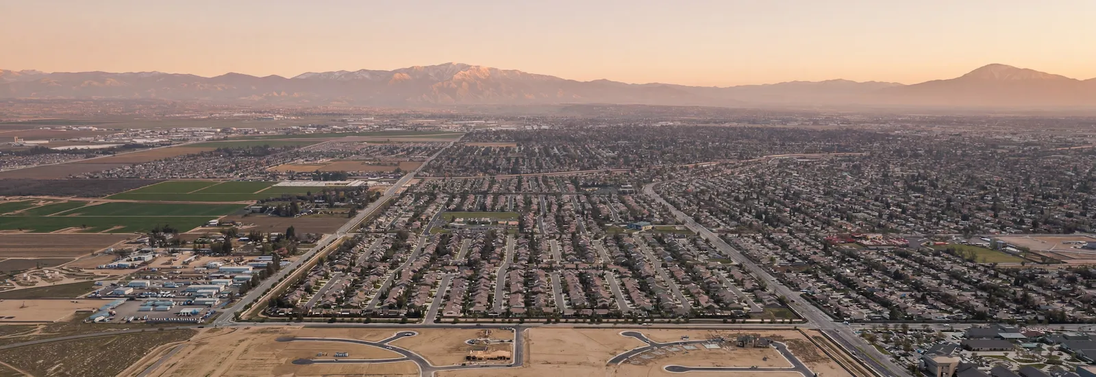 Aerial view of northwest Bakersfield neighborhoods with the mountains at sunset